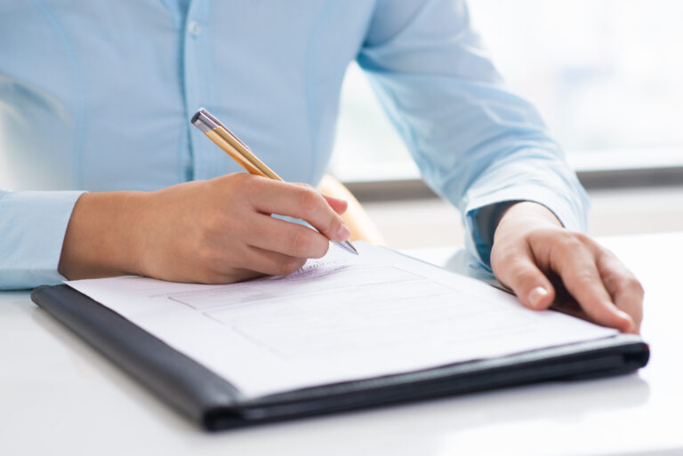 close up of a person signing a permit document